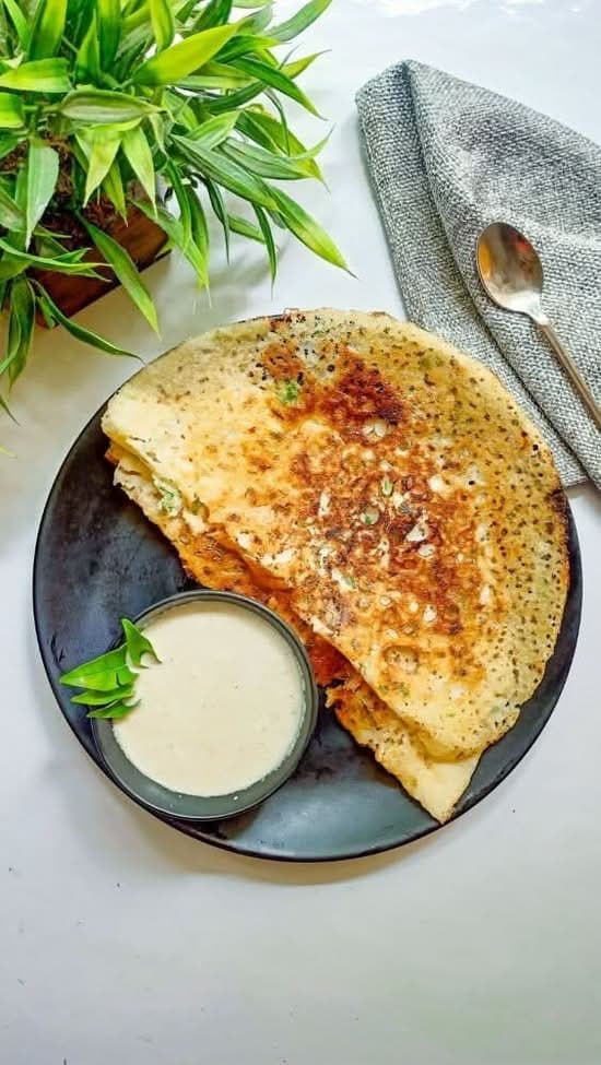 Lacy rava onion dosa scattered with onion and coriander